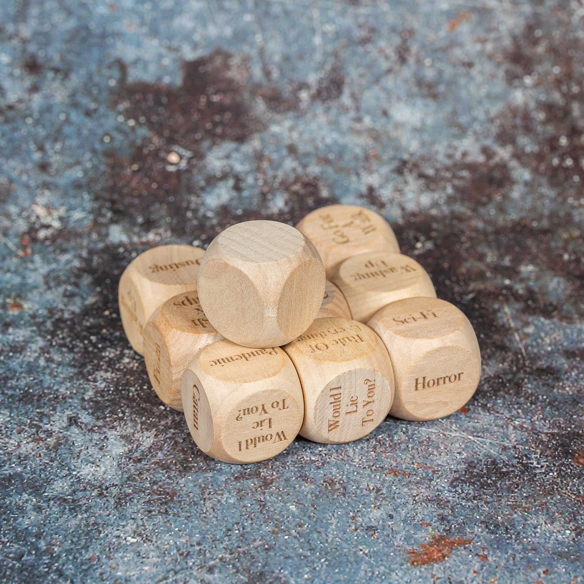 Several laser engraved dice with things such as Horror, sci-fi, Would I lie to you engraved on them.