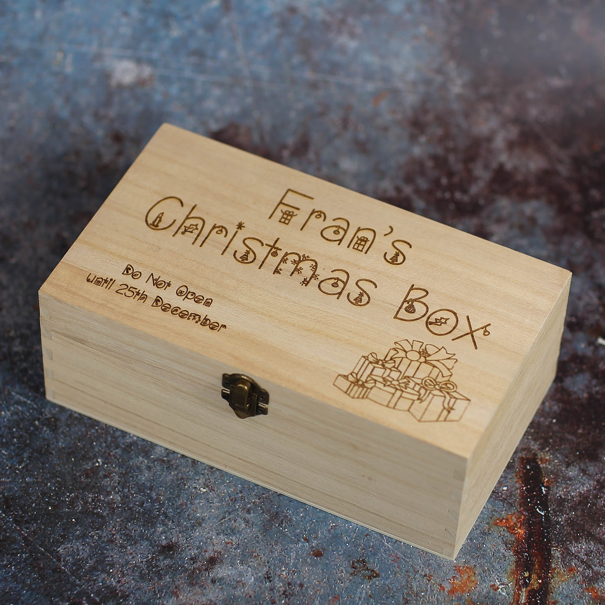 Wooden box with clasp and text saying Fran's Christmas Box. Do Not Open Until 25th December. It has present boxes imagery in the corner.