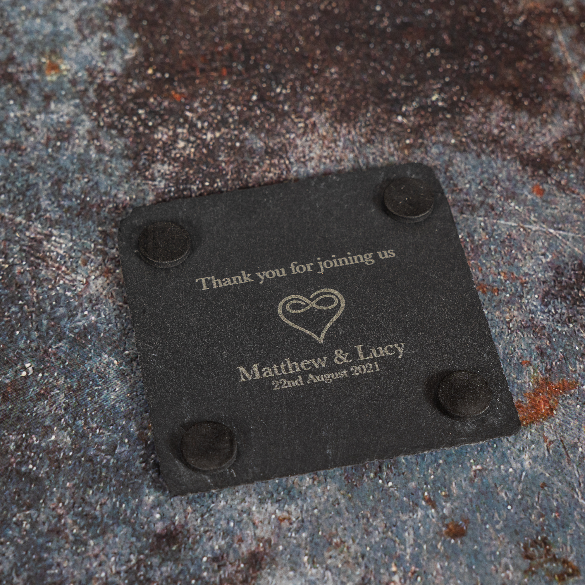 Bottom of slate coasters with wedding message text laser engraved on to it.
