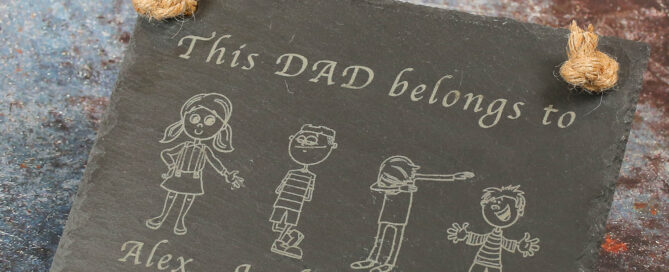 Hanging slate sign with jute rope. Text says This Dad Belongs to and then images of characters and their names.