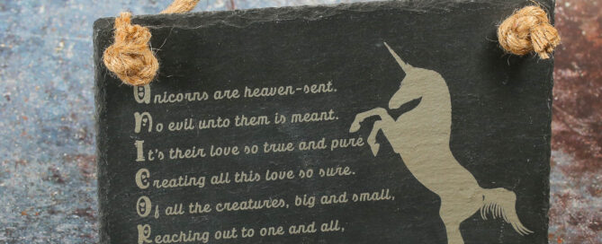 Engraved slate sign with acrostic unicorn poem and unicorn imagery.