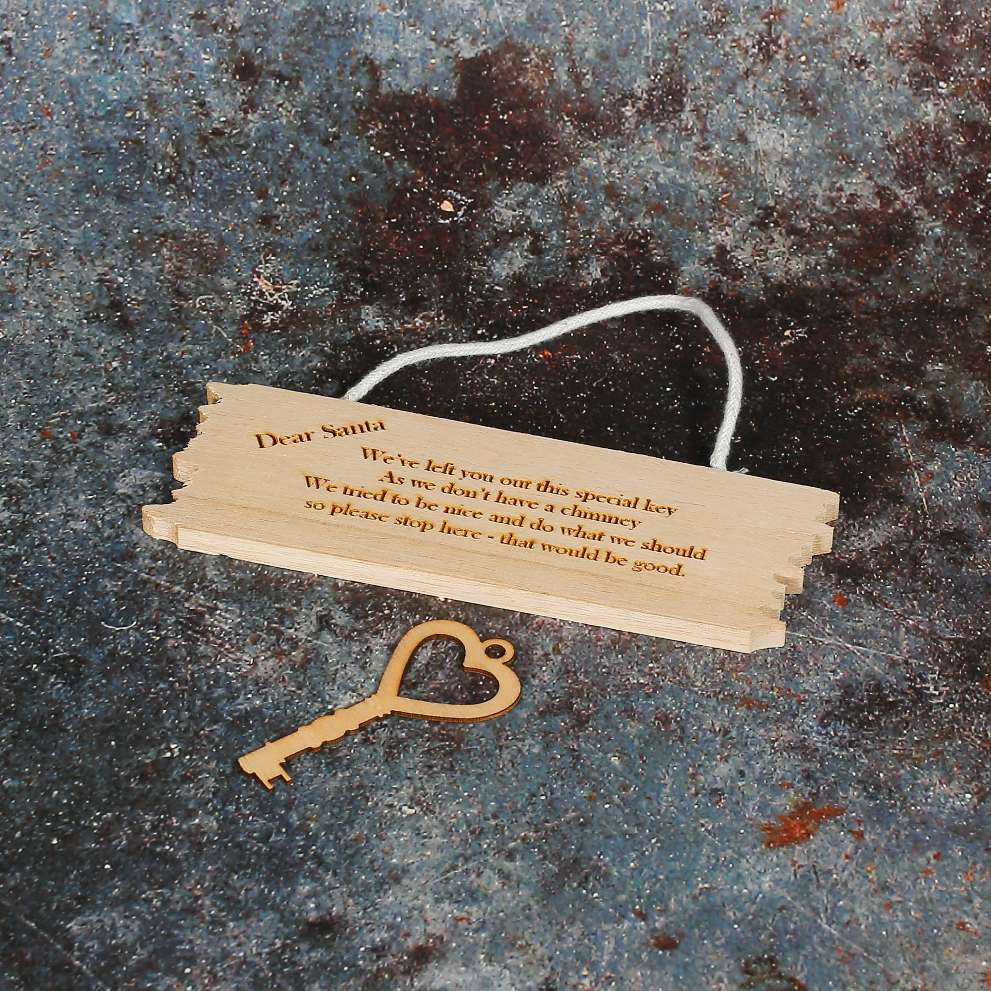 Wooden sign with a wooden key beneath it asking Santa to stop here.