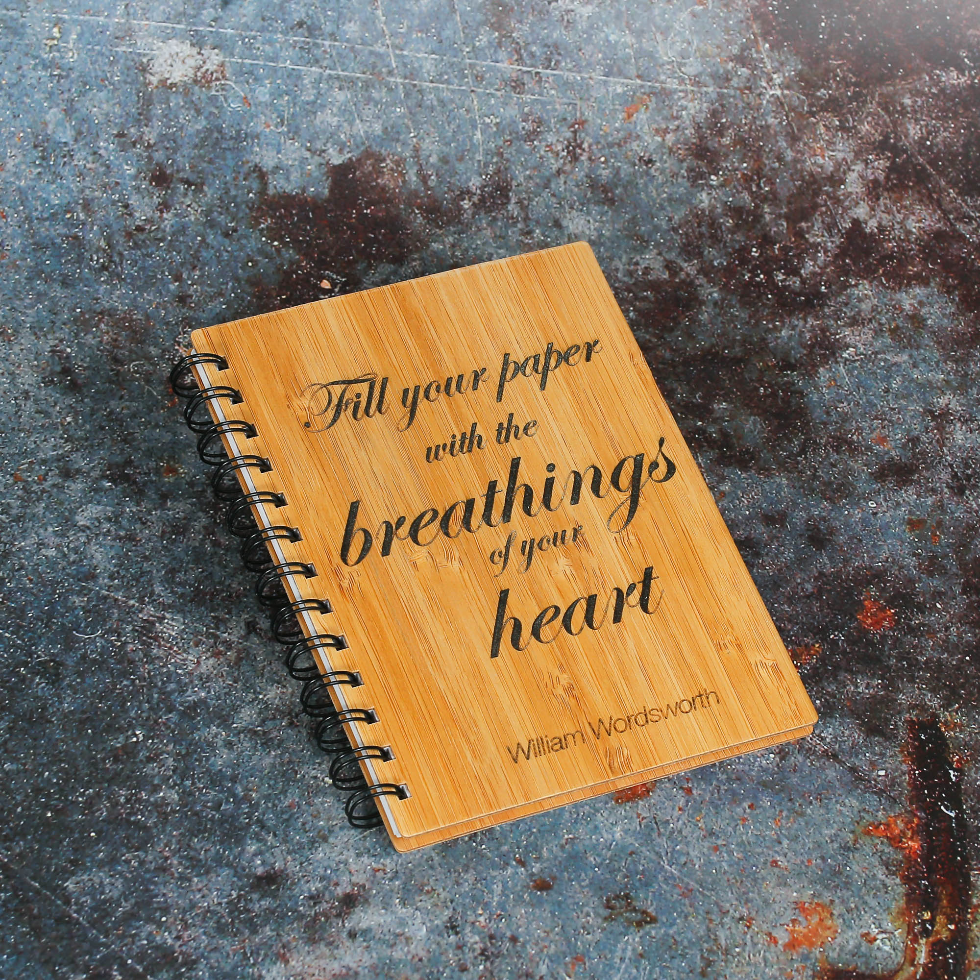 Bamboo notebook with the quote Fill Your paper with the breathings of your heart by William Wordsworth engraved onto the cover.