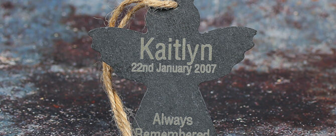 Angel shaped tree hanging with a name, a date and always remembered engraved on it.