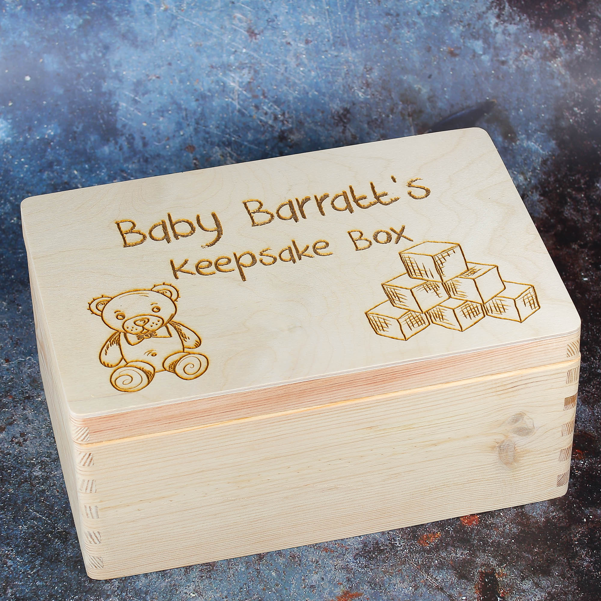 Wooden Box with Keepsake box text alongside teddy and building block imagery.