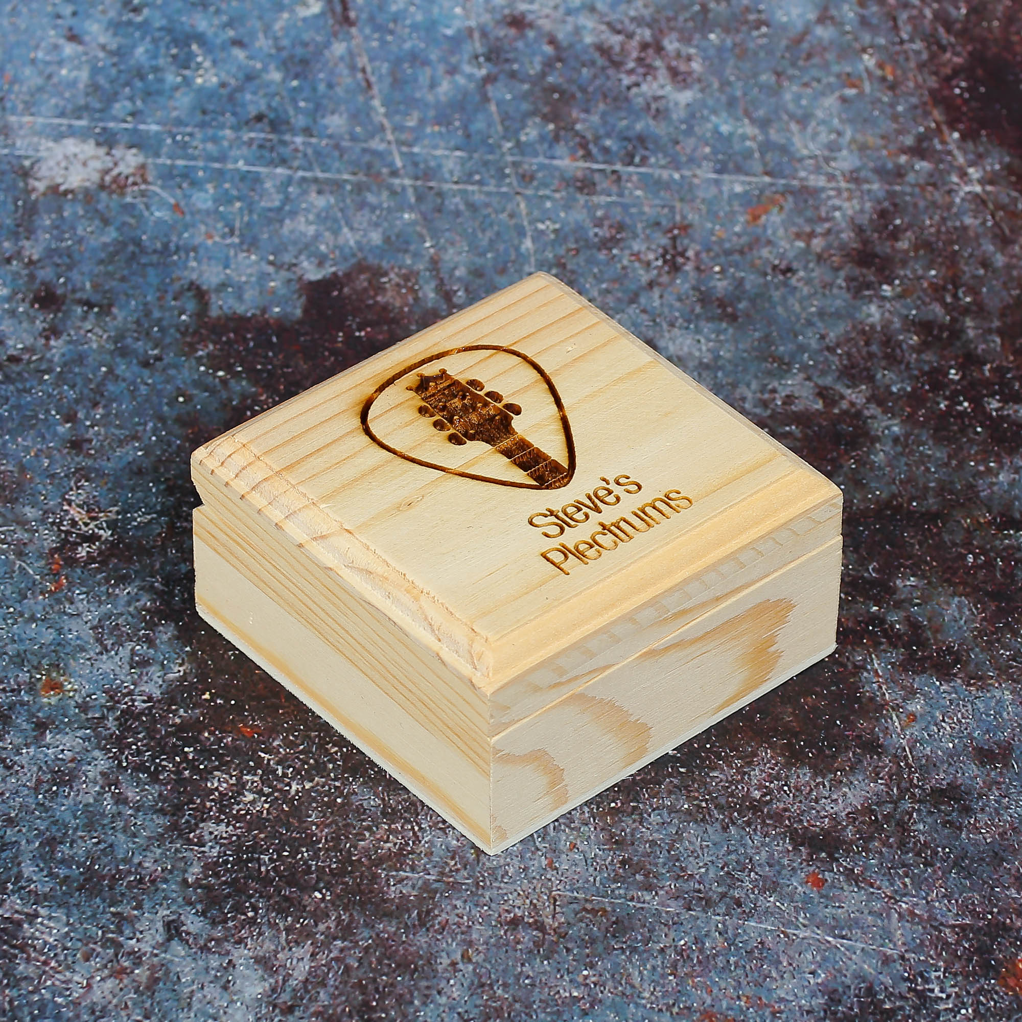 Square wooden box with guitar plectrum imagery and text saying Steve's Plectrums.