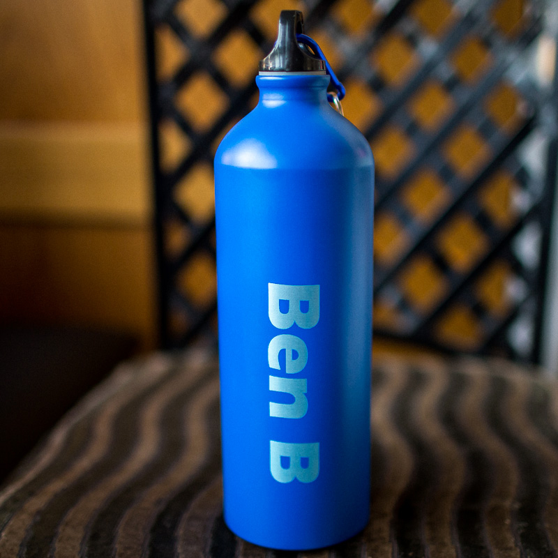 Blue aluminium water bottle with a name laser engraved on it.