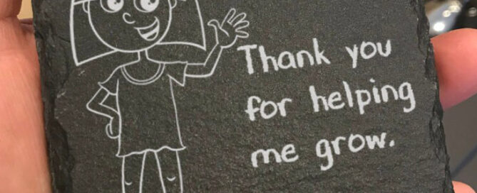 Slate coaster with a cartoon image of a young girl and the words Mrs Owen, Thank you for helping me grow, Georgie engraved on it.
