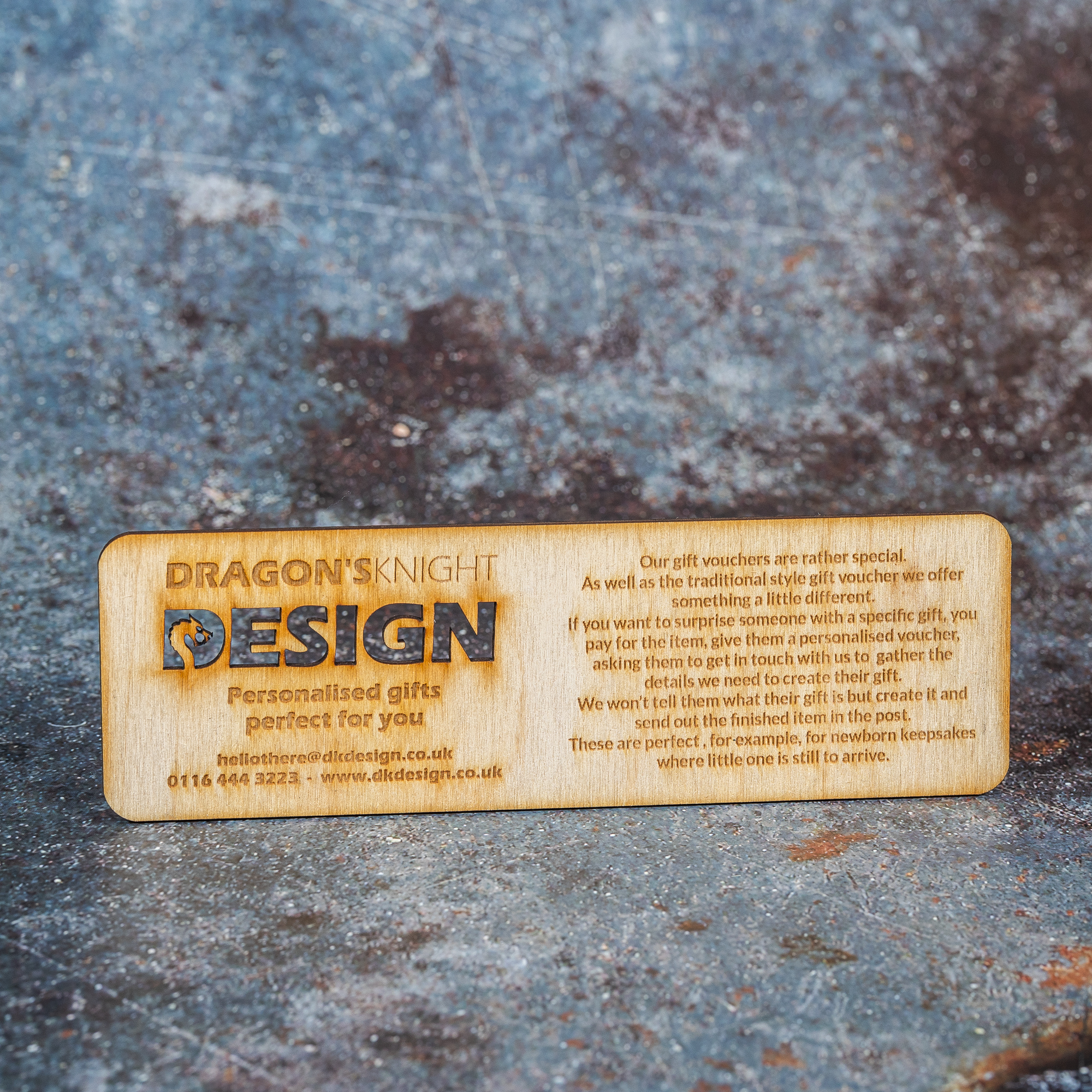 Wooden rectangle engraved with text regarding how the business's gift vouchers work.