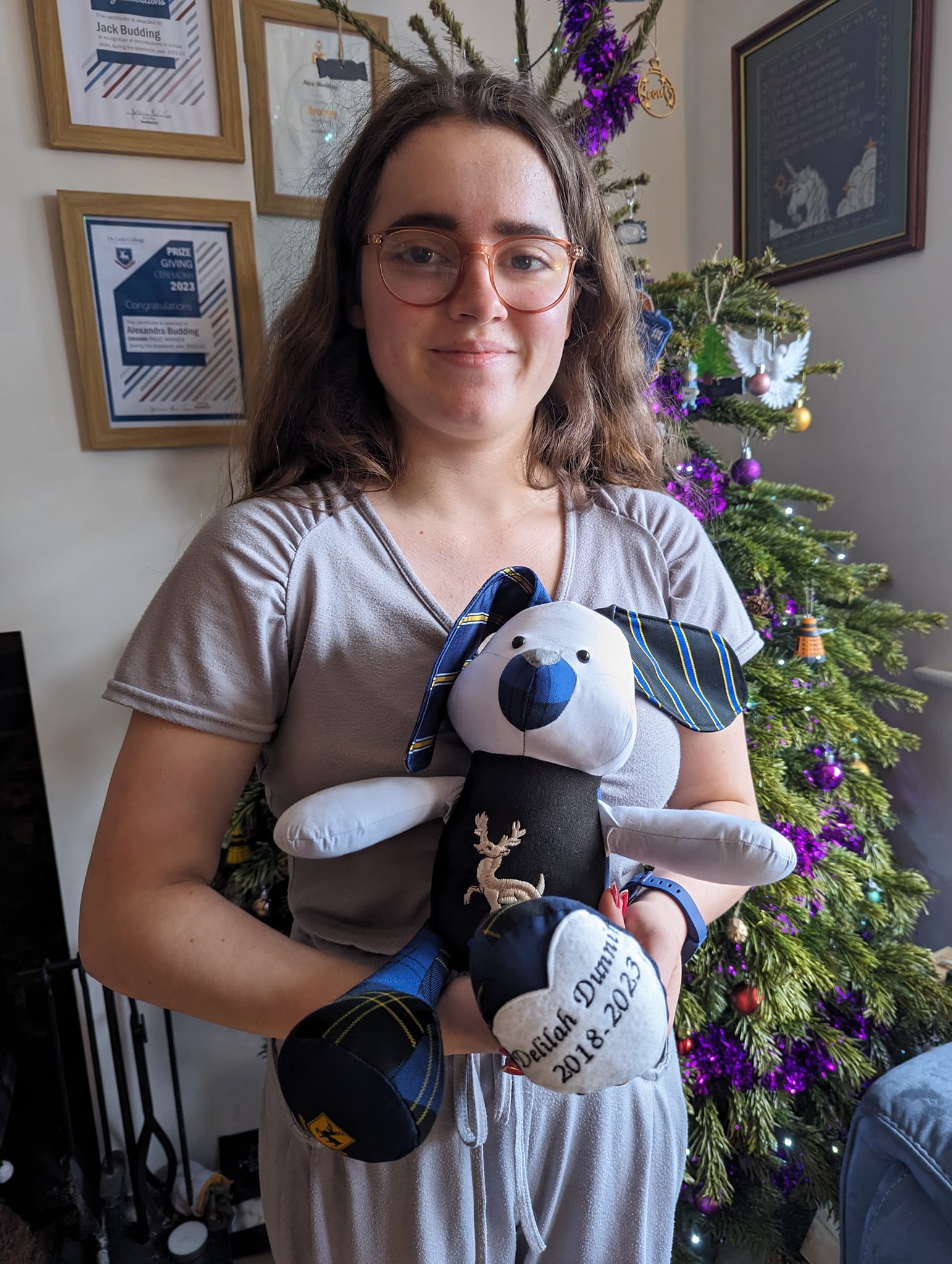 Image of a girl holding a stuffed memory rabbit created from ties, a shirt and a blazer pocket.