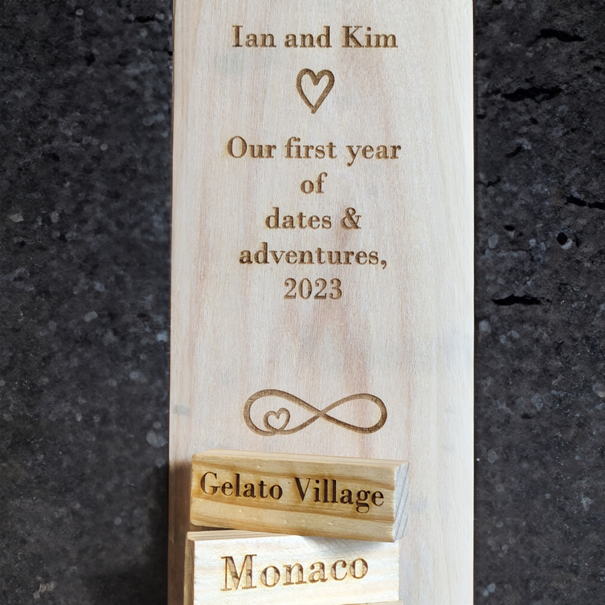 Back of a tumble tower box with personalised text and heart imagery. There are also two tumble tower blocks laser engraved with days out.